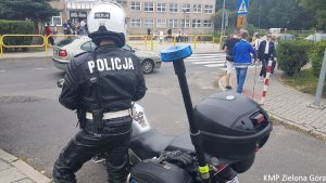 Policjant na motocyklu pilnuje bezpieczeństwa przy jednej ze szkół