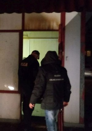 Policjanci przed drzwiami nielegalnego salonu gier