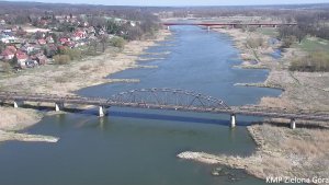 Widok z drona rzeki oraz mostu w oddali Policyjny radiowóz