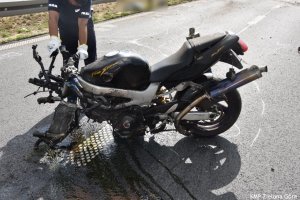 Policjant trzyma uszkodzony motocykl
