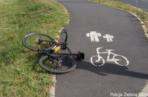 Uszkodzony rower leżący na ścieżce rowerowej.