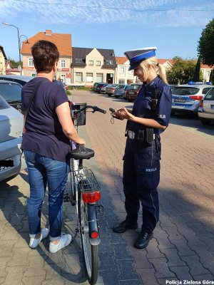 Policjantka sprawdzająca stan trzeźwości i dowód tożsamości u rowerzystki.