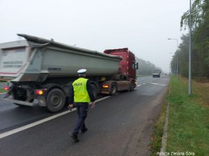 Policjant na drodze kieruje ciężarówkę do kontroli