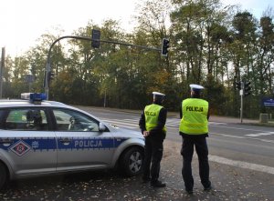 Dwóch policjantów Ruchu Drogowego stoi przy drodze koło cmentarza na ulicy Wrocławskiej