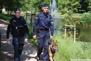 Dwóch policjantów i pies spacerujący nad jeziorem